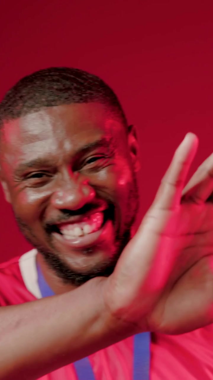Video verticale: Uomo con maglia rossa che tiene la coppa in primo piano, si sposta di lato mostrando la medaglia dopo la vittoria in studio