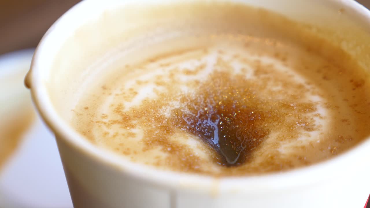 Close-up of a Cup of Coffee with Foam and Brown Sugar