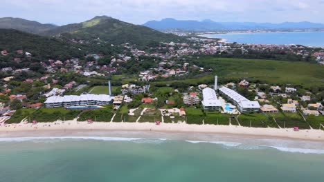 vista aérea por drones de la playa turística con varias casas de verano frente al mar con mucha vegetación y naturaleza
