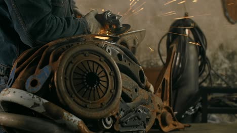 cerrajero arena el metal decorativo escultura de pez steampunk por molinillo eléctrico con muchas chispas en cámara lenta, metalurgia en taller, 4k 60p prores hq
