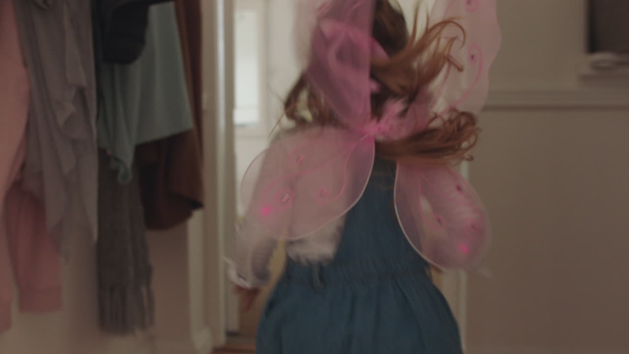 hermosa niña corriendo por la casa con lindas alas de mariposa saltando en la cama jugando a un juego de simulación disfrutando de la imaginación infantil en casa imágenes de 4k