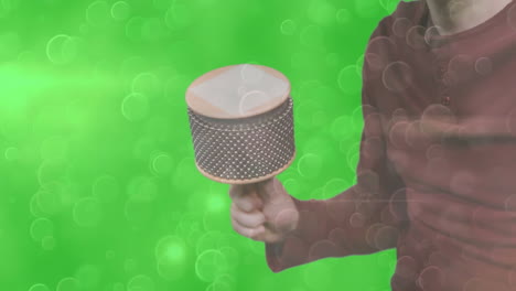 Instructor demonstrating cabasa rhythm in music education tutorial, with animated sound waves