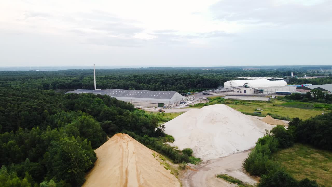 New modern factories and sand piles for construction, aerial view