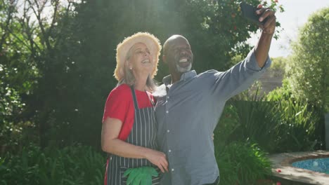 Feliz-Pareja-Diversa-Senior-Tomando-Selfie-En-El-Jardín