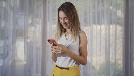 Junge-Frau-Blickt-Jubelnd-Auf-Das-Telefon.