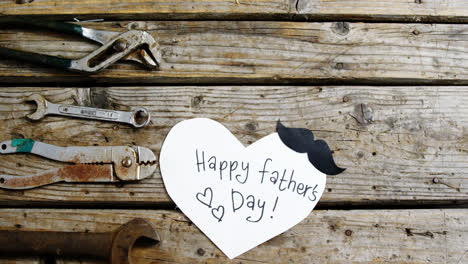 happy fathers day card with old work tools on wooden plank