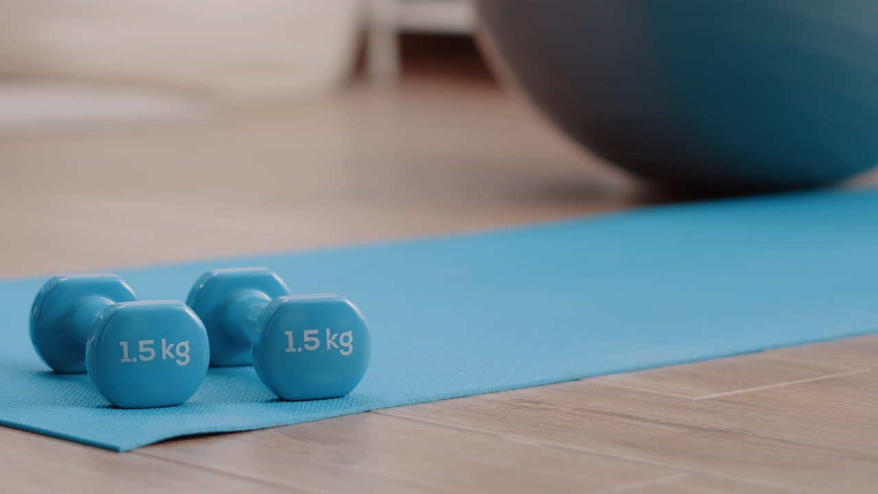 Close up of blue dumbbells on floor yoga mat to train muscles