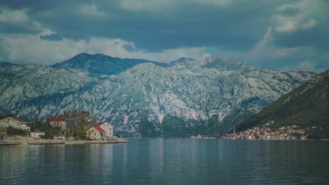 Cinemagraph-De-Un-Antiguo-Pueblo-En-La-Laguna-Cerca-De-Kotor-En-Montenegro-Con-Montañas-Al-Fondo-Y-El-Agua-Moviéndose-Suavemente