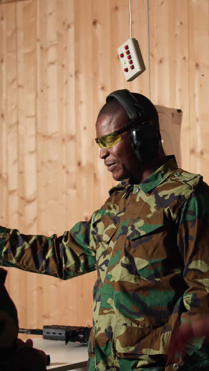 Vertical video Portrait of joyous army soldiers wearing safety gear in shooting gallery