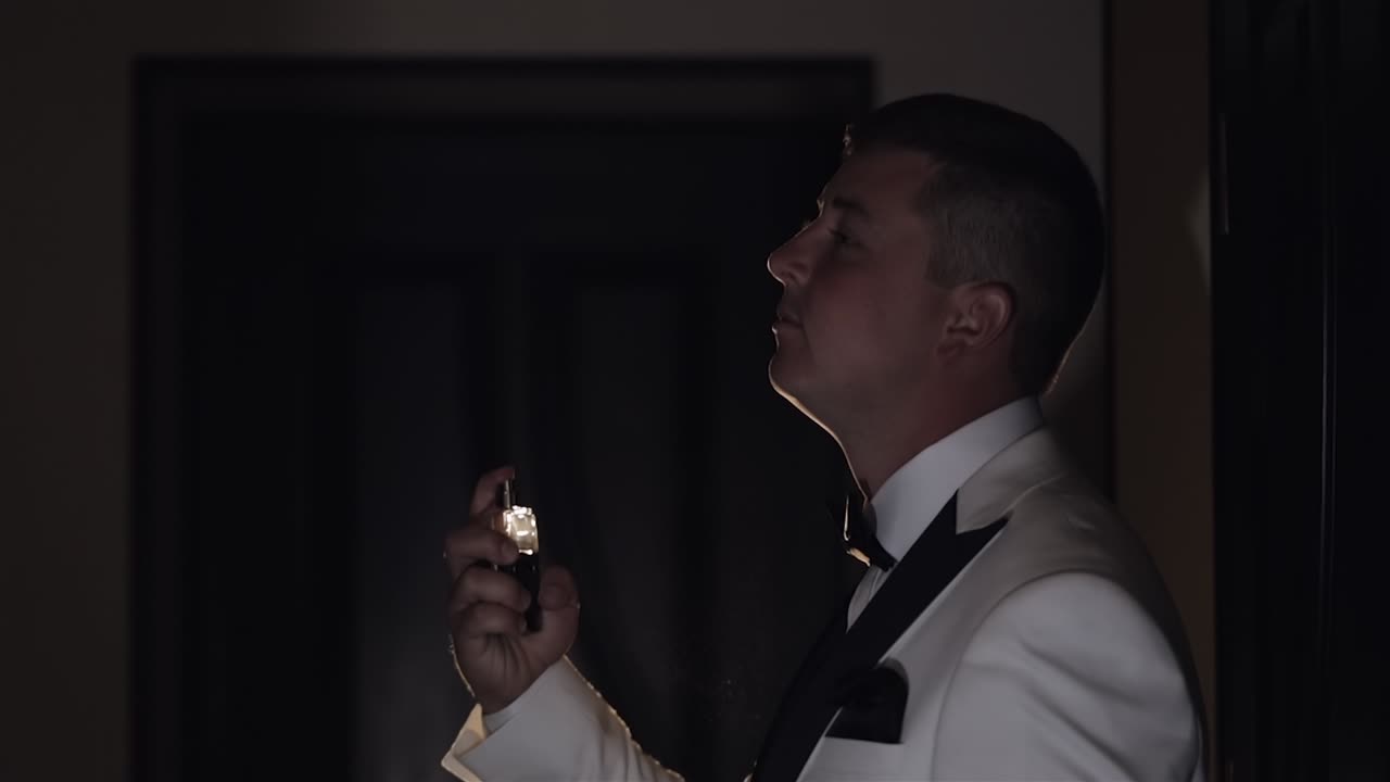 Sposo si spruzza profumo o deodorante, giorno del matrimonio, al rallentatore, uomo d'affari ben vestito