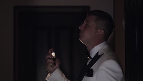 el novio se coloca perfume o desodorante en sí mismo, día de la boda, cámara lenta, hombre de negocios bien vestido
