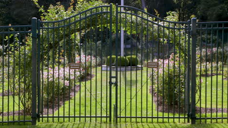 closed metal gate guarding entrance to a public garden on a sunny and bright day