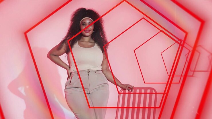 Modella in posa per un servizio fotografico di moda su indicazione del fotografo, facendo scivolare la mano sulla sedia mentre un pentagono rosso incornicia la testa