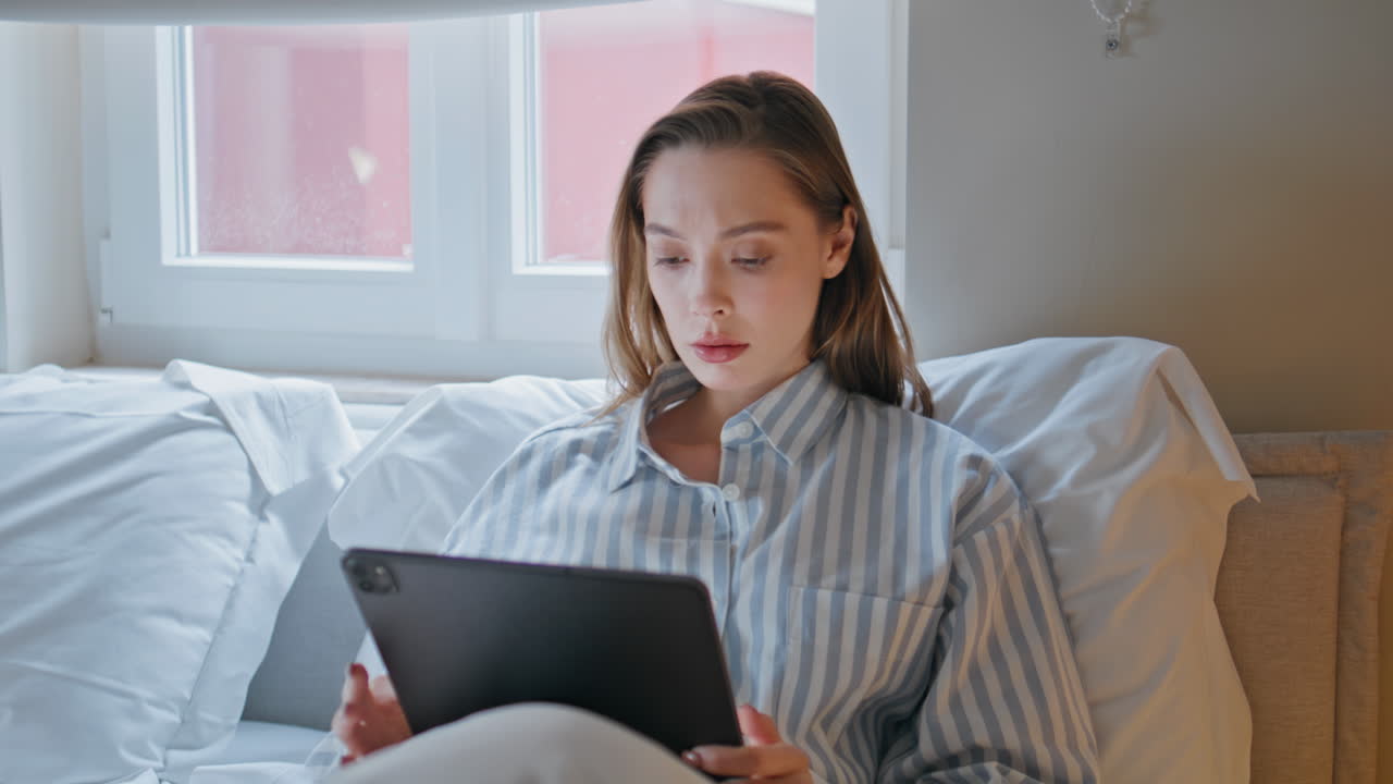Tired woman working bed using tablet closeup. Female writer put off device