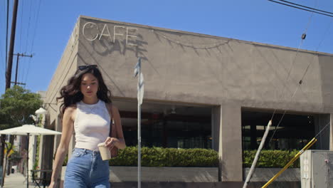 pretty lady taking coffee cup walking street. asian girl crossing road outdoor