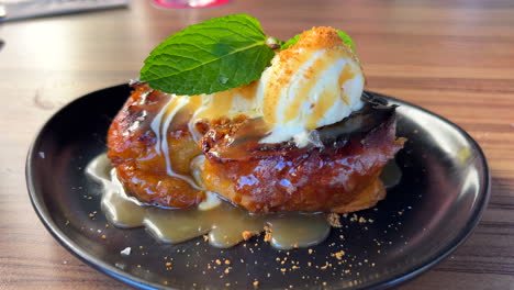 Leckerer-Pain-Perdu-French-Toast-Mit-Vanilleeis-Und-Frischen-Minzblättern-Auf-Einem-Teller,-Süßes-Dessert-In-Einem-Restaurant,-4k-Aufnahme