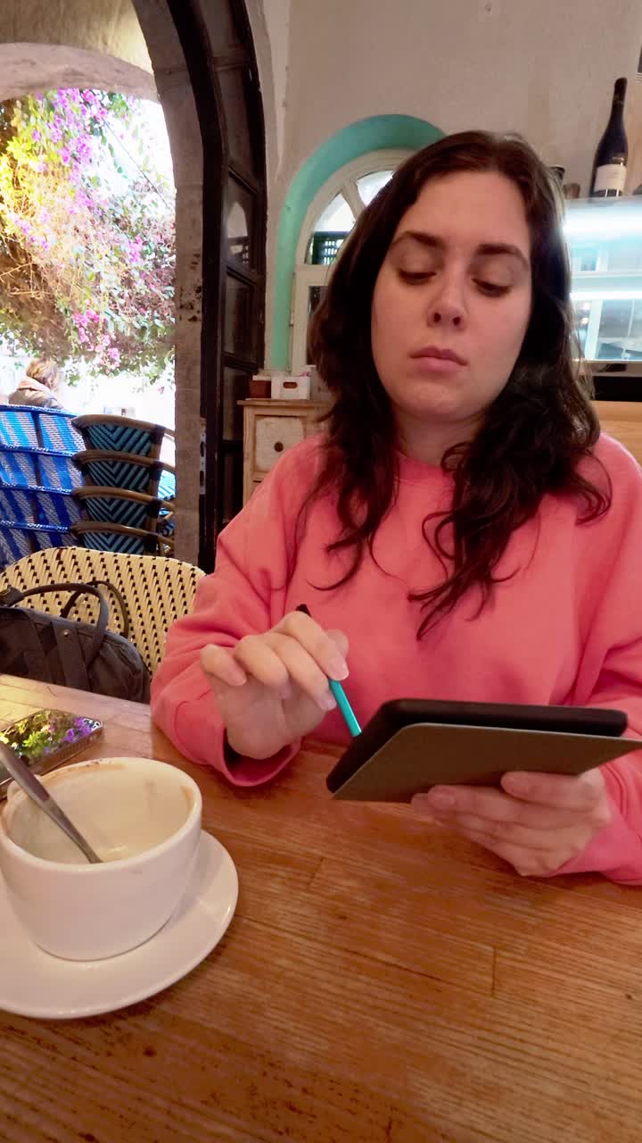 Young woman using a tablet and stylus in a cafe