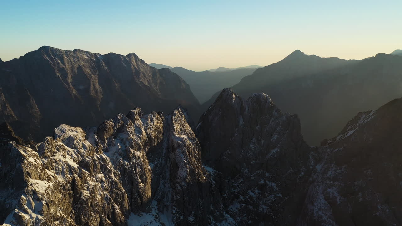 Bidikan drone yang memperlihatkan Gunung Mangart yang tertutup salju di Pegunungan Alpen Julian di Slovenia