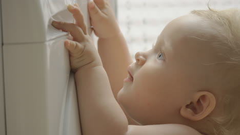 baby girl wants to push the buttons on washing machine