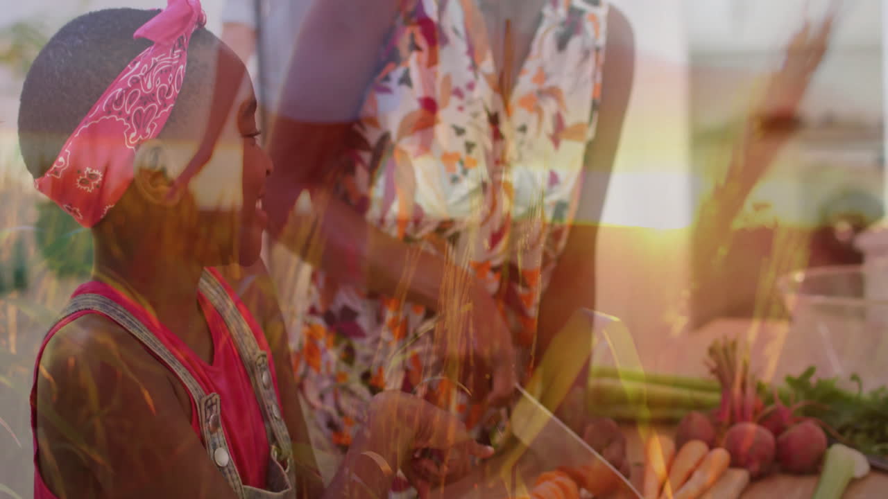 Mother chopping veggies on board in kitchen while daughter watching with animated health icons