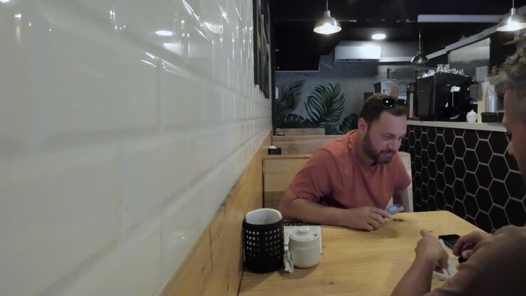 Due uomini che conversano in modo informale in un caffè