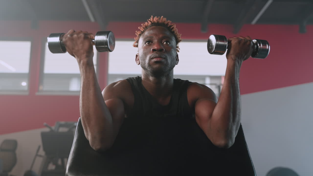 Man Lifting Dumbbells in Gym