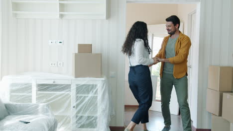 happy couple dancing in their new home