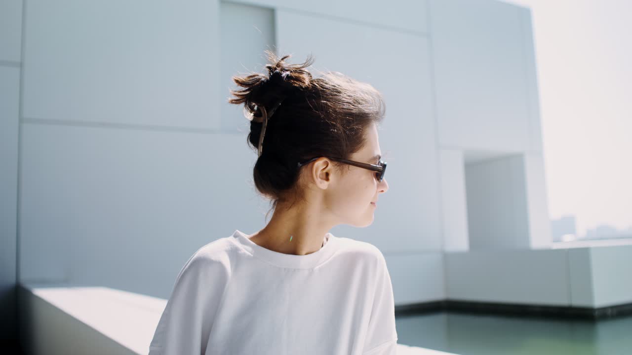 mujer con gafas de sol fuera de un edificio moderno