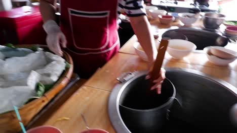 chef boiling noodles in a busy kitchen