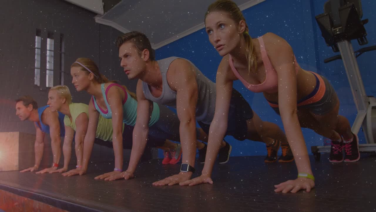 Five trainees answering coach cue, holding high plank on mat, staying aligned for fitness training
