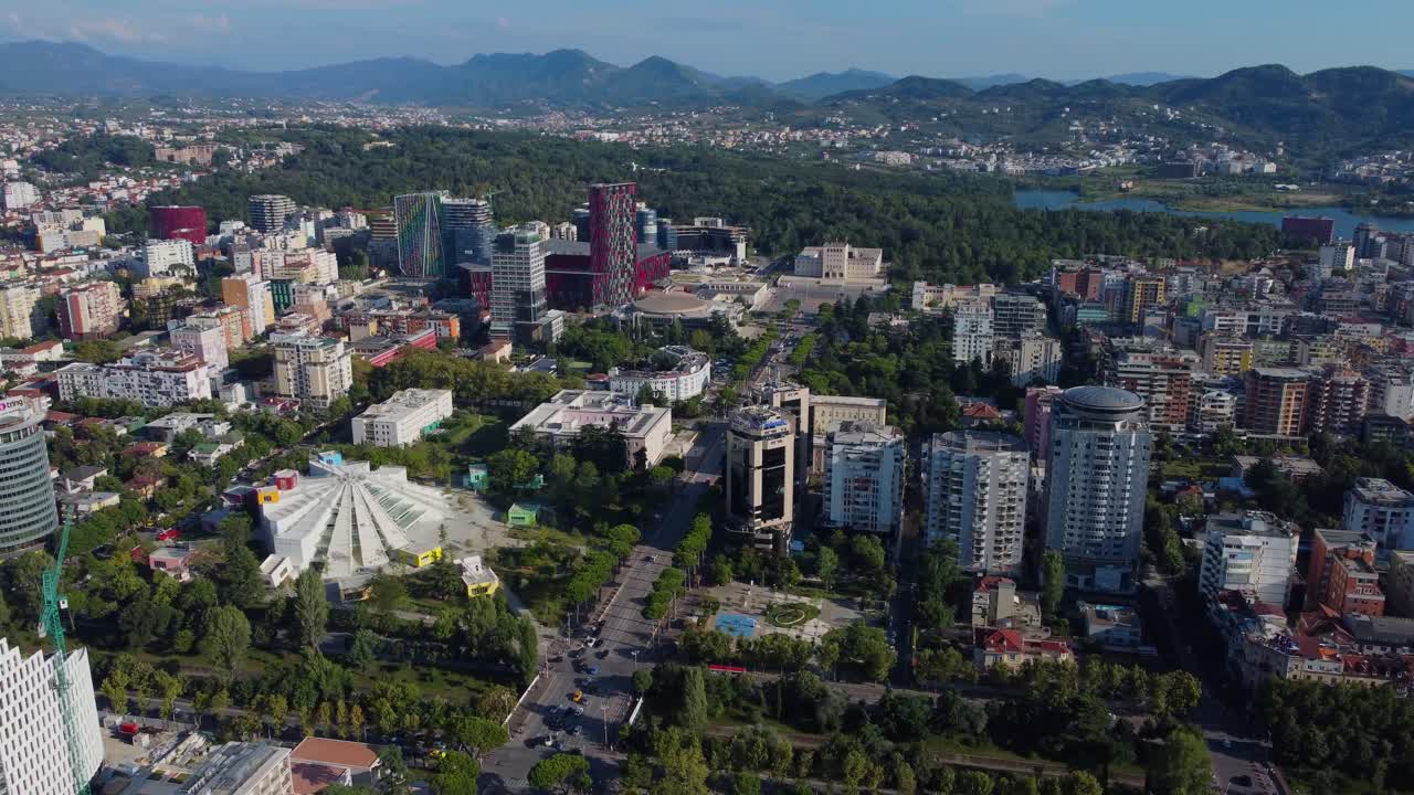 Aerial view of Tirana cityscape in summer with greenery and mountains in the background, Albania