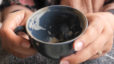 taza de café vacía en las manos