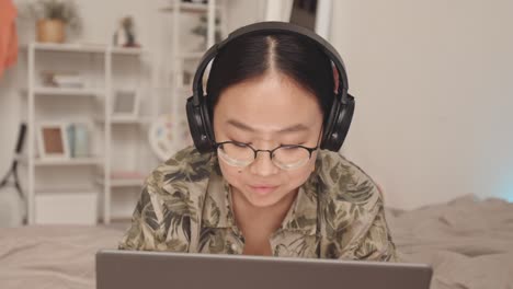 asian zoomer teen girl with laptop at home