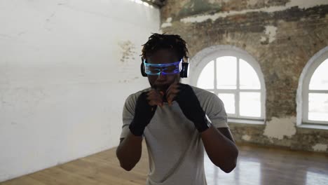 Young-Male-Boxer-Practicing-Shadow-Boxing-In-Light-Sport-Studio