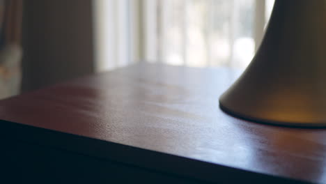 una mano que limpia el polvo y los gérmenes de los muebles de madera con una toallita desinfectante antibacteriana para mantener el hogar familiar sano y seguro contra el virus de la corona o las bacterias