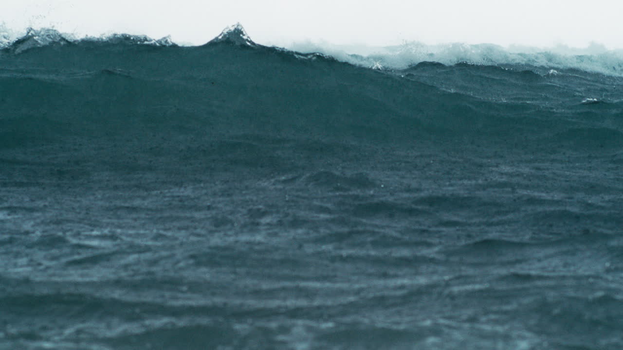 Moody ocean surface under rainfall with dynamic ripples in slow motion