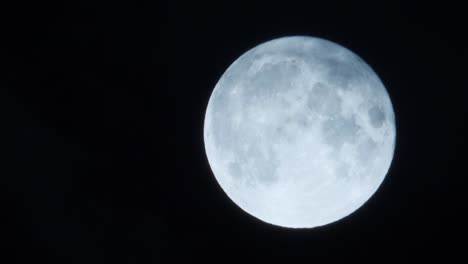 Full-glowing-moon-with-clouds-covering-blown-by-wind,-static,-dark-sky-backgroud