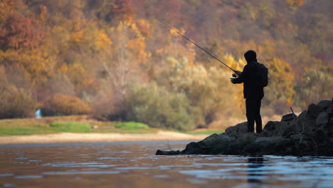 a lone fisherman enjoying the autumn scenery by the lake