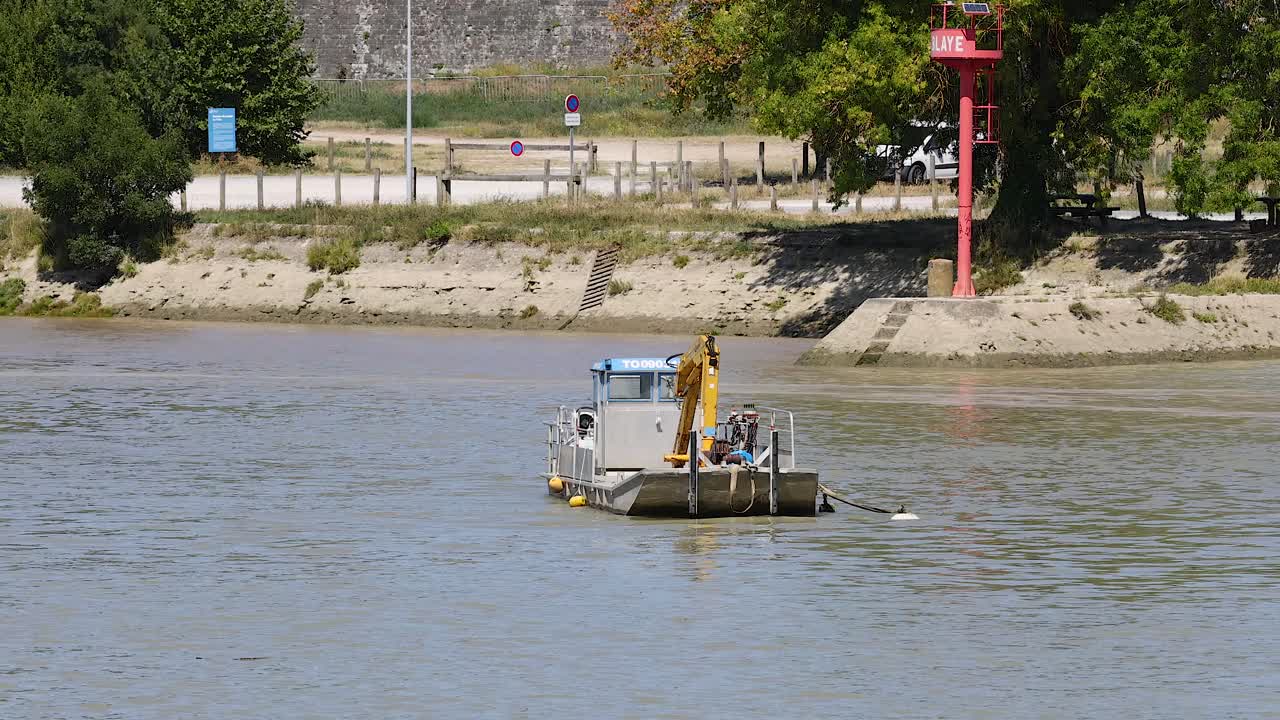 un barco dragando el río cerca de blaye, francia