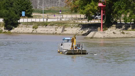 a boat dredging the river near blaye, france