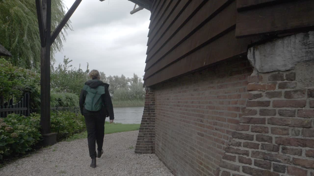 비오는 날 암스테르담 남쪽의 한 마을을 돌아다니는 젊은 여성