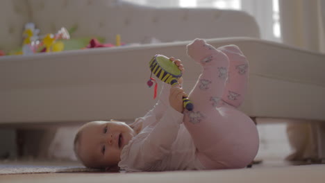 baby girl in warm clothes playing on the floor