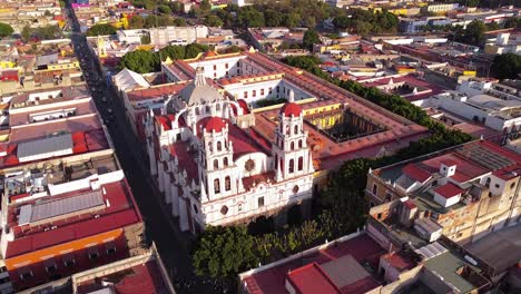 aerial drone backward moving shot over parish of the holy guardian angel of analco or temple of analco in puebla city, puebla, mexico during morning time