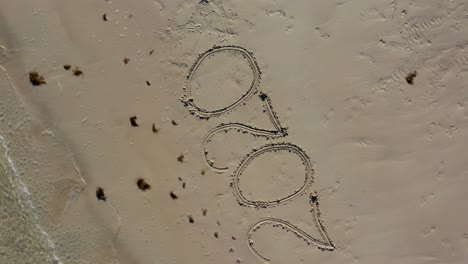 Aerial-camera-showing-a-crazy-Twenty-Twenty-inscribed-in-sand-as-it-turns-counter-clockwise-around-and-around