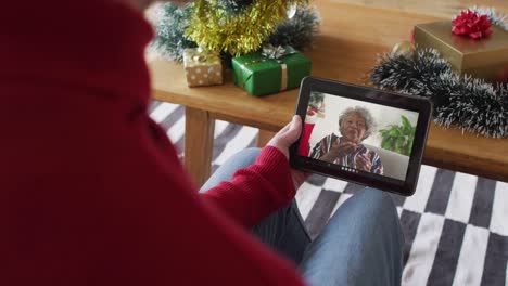 Hombre-Caucásico-Usando-Tableta-Para-Videollamada-Navideña,-Con-Familia-Sonriente-En-Pantalla