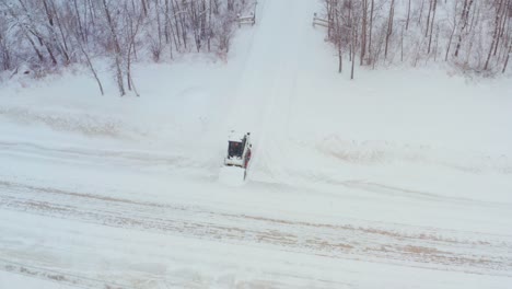 clearing snow on a rural property with a wheeled bobcat