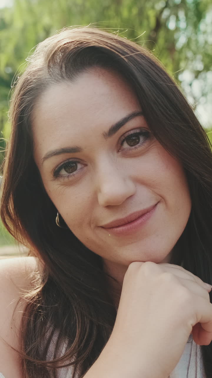 Close-up portraits of a smiling brunette woman outdoors