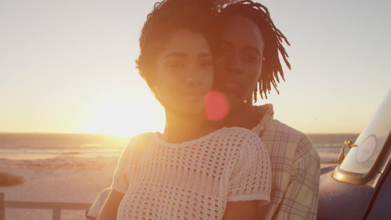 Man embracing woman near pickup truck at beach 4k