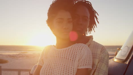 man embracing woman near pickup truck at beach 4k