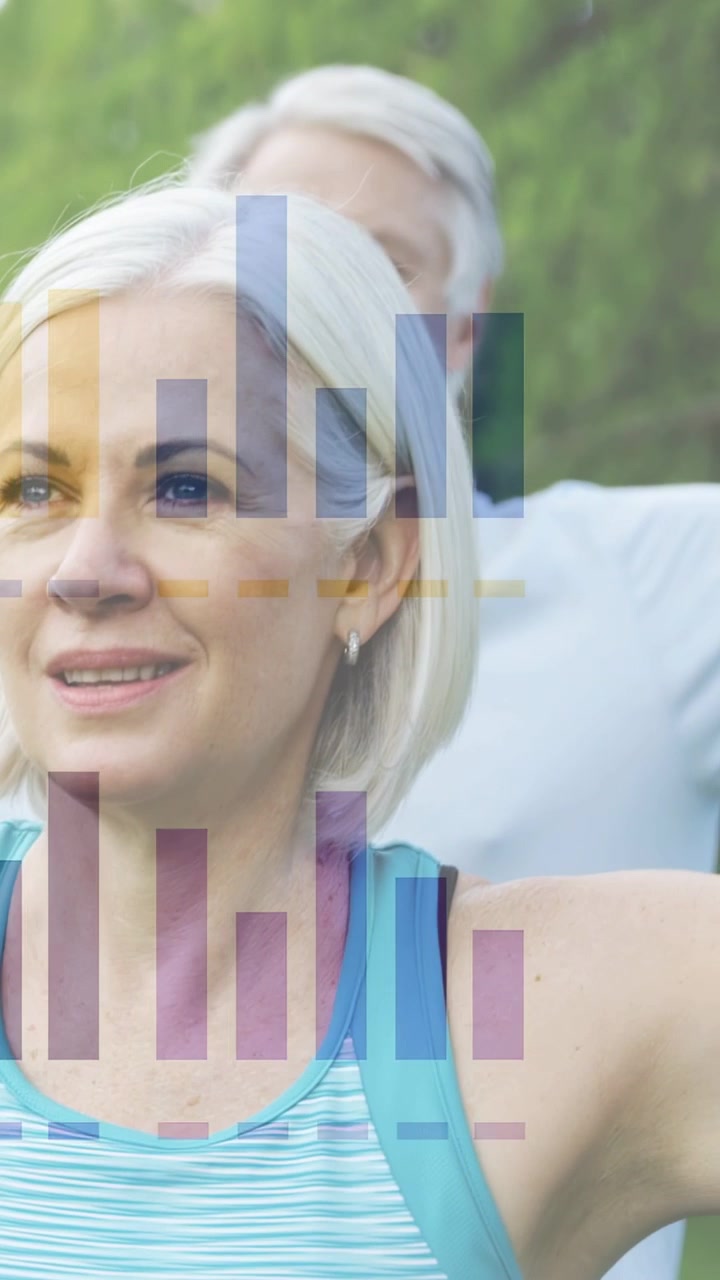 Mature woman doing arm stretch, raising arms causing chart overlay tracking fitness, partner behind